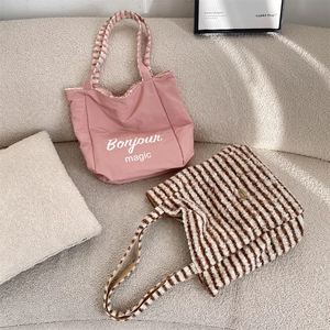 Dual-sided reversible tote bag featuring pink canvas and striped plush textures
