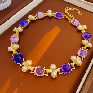 Détail d'un collier vintage avec perles et pierres précieuses dans un écrin de luxe