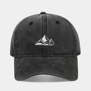 Detailed macro view of white mountain peak embroidery on washed cotton baseball cap