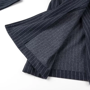 Dettaglio del cappotto in lana a righe blu navy con fodera grigia e orlo ben rifinito