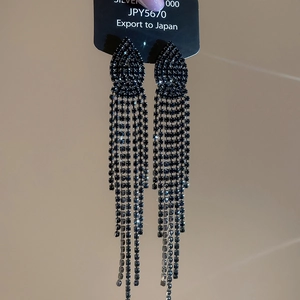 Macro shot of sparkling black crystal jellyfish tassel earrings on silver needles display