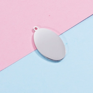 Polished silver stainless steel oval tag charm for DIY jewelry making on dual-color background