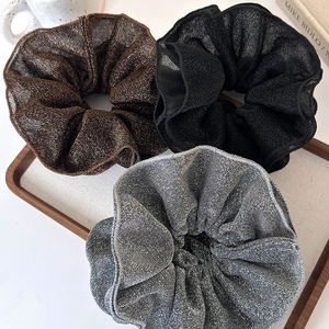 Three premium shimmering grey and black layered organza scrunchies on wooden tray