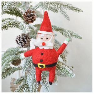 Handmade wool felt Santa Claus ornament hanging on a snowy Christmas tree branch