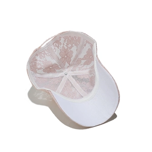 Dettaglio del pizzo floreale rosa e della fodera bianca interna del cappellino traspirante