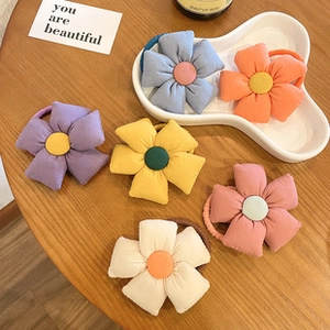 Close-up of colorful floral fabric elastic hair ties on a wooden table and tray
