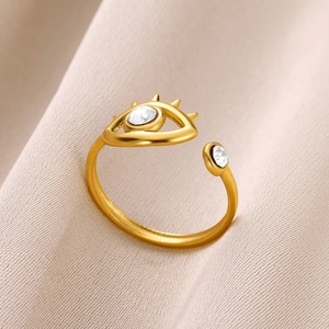 Macro detail of gold-plated evil eye ring with sparkling zircon insets on silk fabric