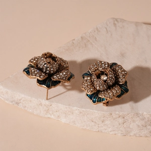 Detailed close-up of vintage flower earrings with blue enamel and pavé crystals