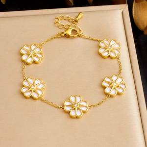 Gold stainless steel flower bracelet with white petals and zircon centers on gift box