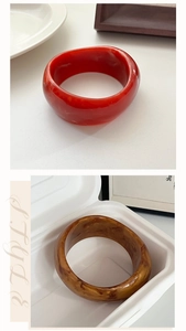 Macro detail of wide resin bangle showing dark red and amber marble textures