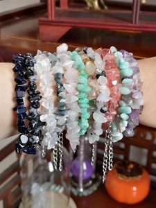 Close-up of stacked natural gemstone chip bracelets with adjustable metal chains