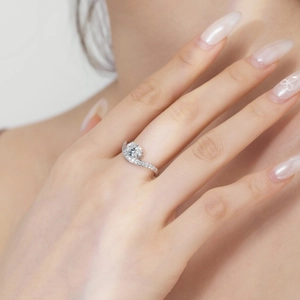 Close-up of S925 silver ring on finger with round main stone and pave diamond accents