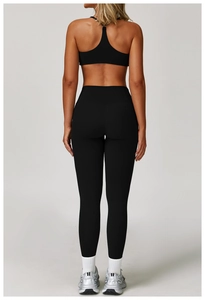 Rear view of black racerback sports bra and high-waisted yoga leggings set on model