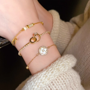 Detail of gold-plated bamboo link bracelet set with white clover and sparkling zircon
