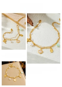 Detail of double-layer gold anklet with pearl, elephant and leaf charms on stone