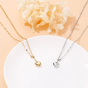 Chic gold and silver heart pendant necklaces on a white tray for women