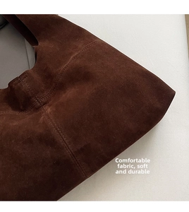 Detailed close-up showing precision stitching and premium suede texture on the brown tote bag