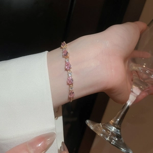 Detail of pink pear-cut zircon bracelet with gold setting worn for an elegant evening look