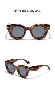 Macro detail of tortoise sunglasses showing gold leaf accents and dark gray lenses