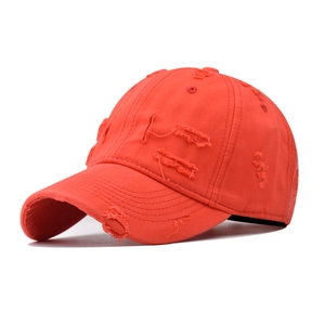 Close-up of bright red distressed cotton baseball cap showing vintage worn edge details