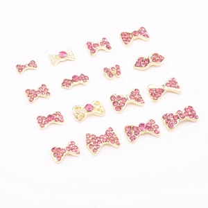 Bow-shaped nail art charms with pink rhinestones in gold and silver alloy finish