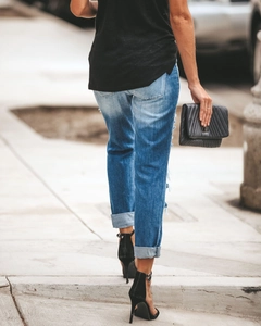 Vue arrière d'un jean bleu ajusté avec déchirures pour femmes style urbain chic