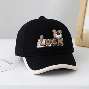 Détail de la casquette de baseball bébé avec lettrage Luck et écusson ours brun
