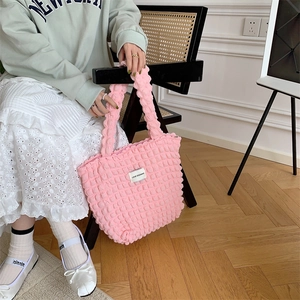 Detailed view of the pink bubble textured tote bag with a white woven brand label