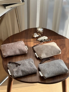 Mini herringbone tweed pouches with 'simple wish' labels and drawstrings on wood table