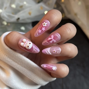 Cute pink gradient almond press-on nails with 3D bunny, bow, and floral accents