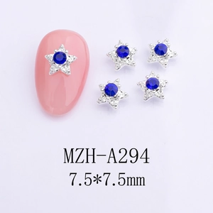 Macro detail of 7.5mm star nail charms with blue rhinestones on silver metal base