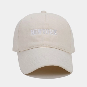 Dettaglio del ricamo bianco NEW YORK sulla superficie del cappello da baseball beige