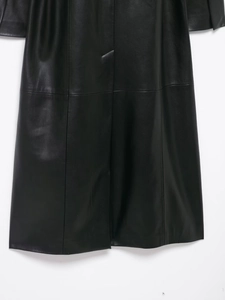 Detail of the high-quality black faux leather fabric texture and stitching on the hemline