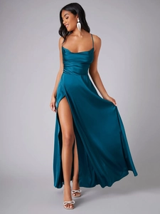 Gros plan d'une robe de soirée en satin bleu paon avec fente haute et drapé élégant