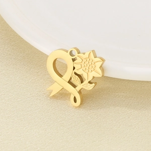 Detailed view of 18K gold plated stainless steel heart and flower pendant with textured surface