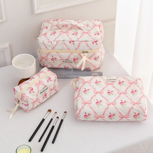 Quilted floral cosmetic bag set with pink rose patterns and bow ribbon details