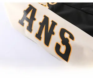 Detail of ANS rubber print and metallic buttons on a warm sports hoodie sleeve
