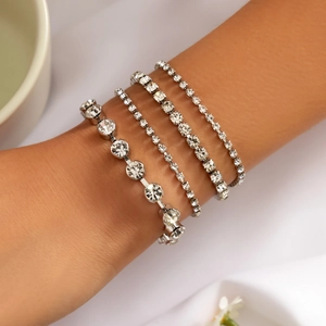 Elegant four-piece silver rhinestone bracelet set with pearls on a model wrist