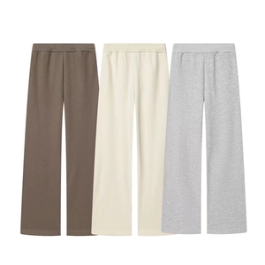 Detail view of wide-leg sweatpants in brown, beige, and grey with elastic waist bands