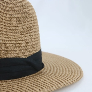 Close-up of tight straw weave texture and black grosgrain ribbon on Panama sun hat