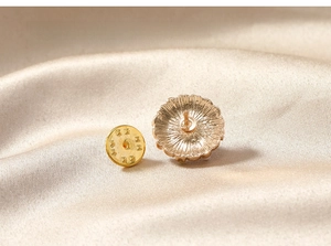 Detailed macro view of the vintage gold flower brooch back with butterfly pin fastener