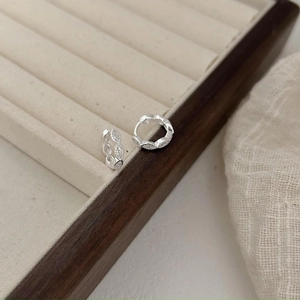 Macro shot of S925 sterling silver marquise diamond hoop earrings on a velvet tray