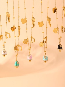 Detail of gold necklaces with colorful enamel bells and sparkling heart pendants