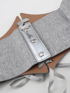 Detail of silver metallic elastic corset belt with brown PU leather and snap buttons