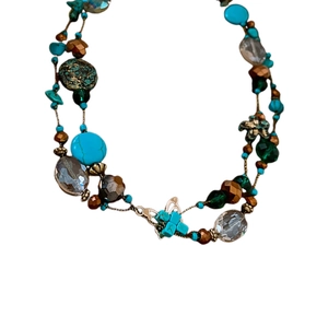 Bohemian multi-layer beaded necklace featuring turquoise accents and butterfly pendant