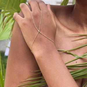 Elegant gold chain hand harness with imitation pearls and rhinestones on a female hand