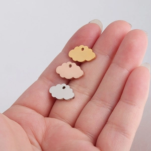 Hand holding cloud shaped stainless steel pendants in gold, silver, and rose gold finishes