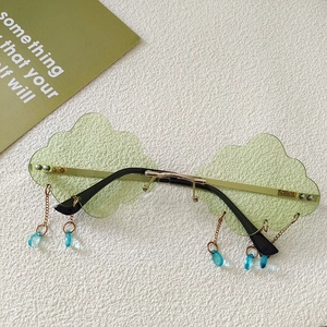 Close-up of cloud-shaped light green sunglasses with gold frame and blue teardrop charms