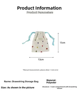 Detailed view of cream polyester drawstring pouch with colorful dots and size info
