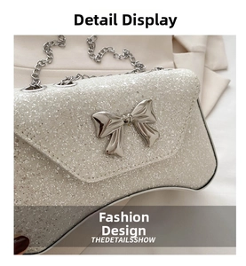 Detailed shot of white glitter crossbody bag with silver bow clasp and chain strap